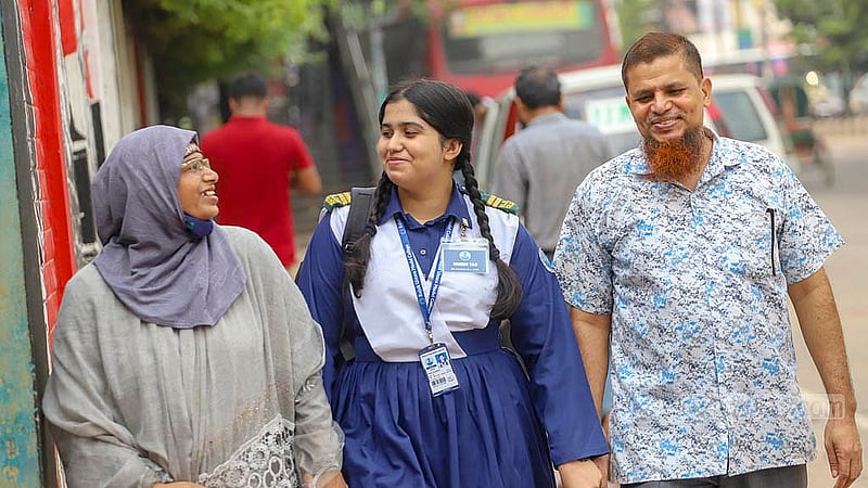 এইচএসসি পরীক্ষায় জিপিএ-৫ পাওয়ায় খুশি বাবা-মা। রাজউক উত্তরা মডেল কলেজ থেকে সন্তানকে নিয়ে বাড়ী ফিরছেন তারা।ছবি: আব্দুল্লাহ আল মমীন