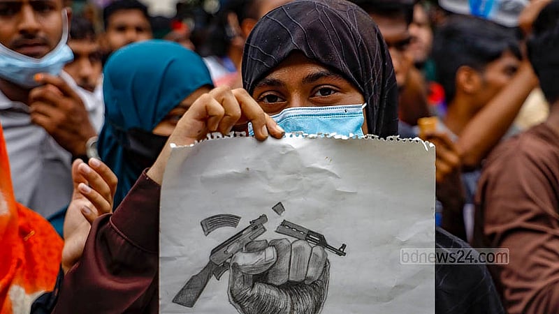 বিভিন্ন দাবির প্ল্যাকার্ড হাতে শনিবার ঢাকার আফতাবনগরের ইস্ট ওয়েস্ট বিশ্ববিদ্যালয়ের সামনে শিক্ষার্থীরা। ছবি: মাহমুদ জামান অভি
