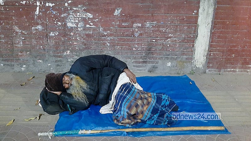 হাড় কাঁপানো ঠান্ডার মধ্যে রাজধানীর সেগুনবাগিচা এলাকায় ফুটপাতে রাতযাপন করছেন এক বৃদ্ধ। ছবি: আব্দুল্লাহ আল মমীন