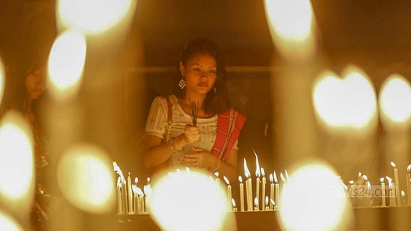 প্রবারণা পূর্ণিমায় বুধবার ঢাকার বাসাবো ধর্মরাজিক বৌদ্ধবিহারে মোমবাতি জ্বালাচ্ছেন করেন এক পুণ্যার্থী।