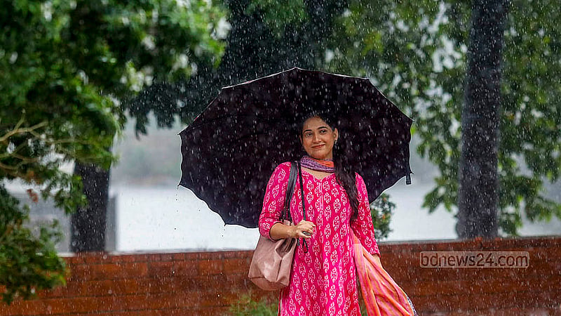 ভর দুপুরে আকাশ আঁধার করে নামে বৃষ্টি, ছাতা হাতে হাতিরঝিলে বৃষ্টি উপভোগ করতে দেখা যায় এক তরুণীকে। ছবি: মাহমুদ জামান অভি
