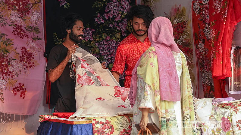 বাংলা একাডেমি প্রাঙ্গণে বৈশাখী মেলায় ঘুরতে আসা অনেকেই পছন্দের জিনিস কিনছেন।