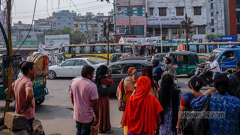 ঢাকার মেরুল বাড্ডা সড়কে সোমবার দুপুরে তীব্র যানজট দেখা যায়। যানবাহনের জটলা উপেক্ষা করে সড়ক পার হন পথচারীরা