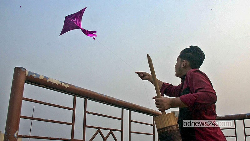 ঐতিহ্যবাহী সাকরাইন উৎসবে বুধবার পুরান ঢাকায় বাড়ির ছাদ থেকে ঘুড়ি উড়াচ্ছেন এক তরুণ।