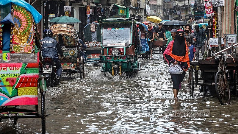 পুরান ঢাকার নাজিরাবাজার রোডে জমে থাকা পানির ওপর দিয়ে চলাচল করছে সবাই।