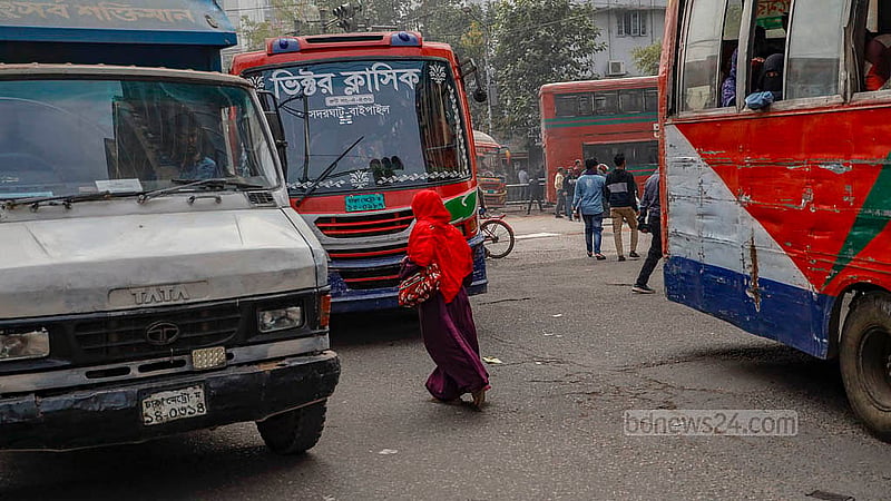 ঢাকার পল্টন এলাকায় ব্যস্ত সিগন্যালের মাঝে সড়ক পার হতে গিয়ে তিন গাড়ির মাঝে পড়ে বিপাকে এক নারী। ছবি: মাহমুদ জামান অভি