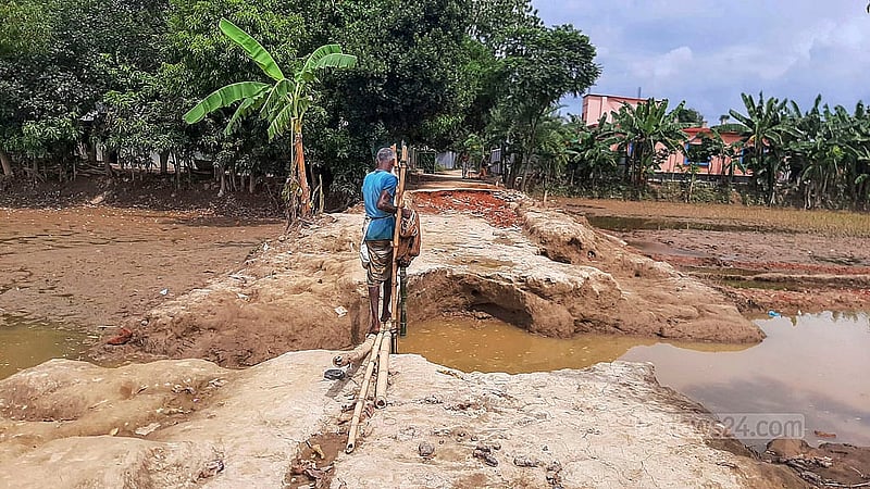 বন্যার পানির স্রোতে ফেনীর পরশুরামের তুলাতলী বাজারের একটি সড়কের মাঝখানে ভেঙ্গে গেছে। ছবি: উত্তম সেন গুপ্ত