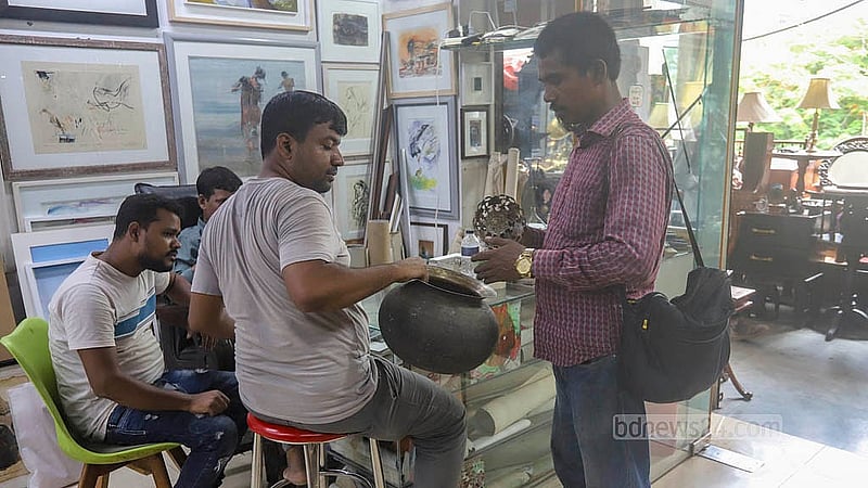 গুলশানে ডিএনসিসি মার্কেটের দোতলায় ‘ডেকোরিয়াম’ শপে কাঁসার পুরনো সামগ্রী বিক্রি করতে আসেন এক ব্যক্তি। ছবি: আব্দুল্লাহ আল মমীন