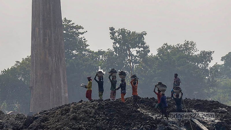 ঢাকা কেরানীগঞ্জের জাজিরা এলাকার একটি ভাটায় বাল্কহেড থেকে মাটি তোলার কাজে ব্যস্ত শ্রমিকরা। এই মাটি দিয়েই বানানো হবে ইট