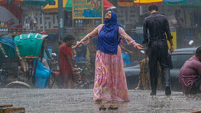 বৃহস্পতিবার বিকেলে ঢাকা বিশ্ববিদ্যালয় এলাকায় বৃষ্টি উপভোগ করছেন এক নারী।
