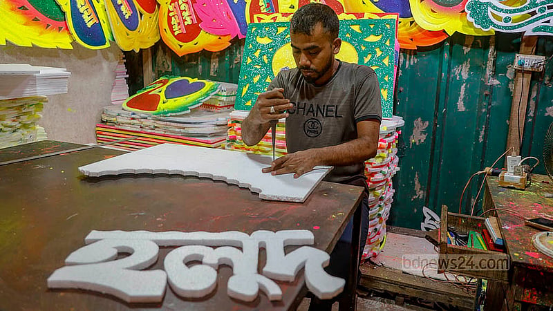 ঢাকার শাহবাগের একটি দোকানে কর্কশিটে ‘গায়ে হলুদ’ বা ‘হলুদ সন্ধ্যা’ লেখার কাজ করছেন এক ব্যক্তি। ছবি: মাহমুদ জামান অভি