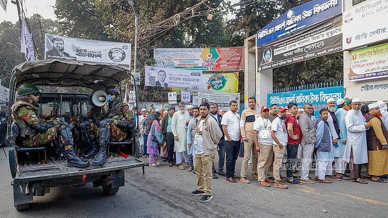 ত্রয়োদশ সংসদ নির্বাচন ও গণভোট দিতে বৃহস্পতিবার সকালে বিটিসিএল আদর্শ বালিকা উচ্চ বিদ্যালয়ের বাইরে এক পাশে ভোটারদের লাইন, অন্য পাশে শৃঙ্খলা বজায় রাখতে নির্দেশনা দিচ্ছেন সেনা সদস্যরা