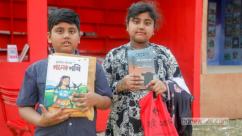 অমর একুশে বইমেলার প্রথম দিন সোহরাওয়ার্দী উদ্যানে বই হাতে দুই শিশু