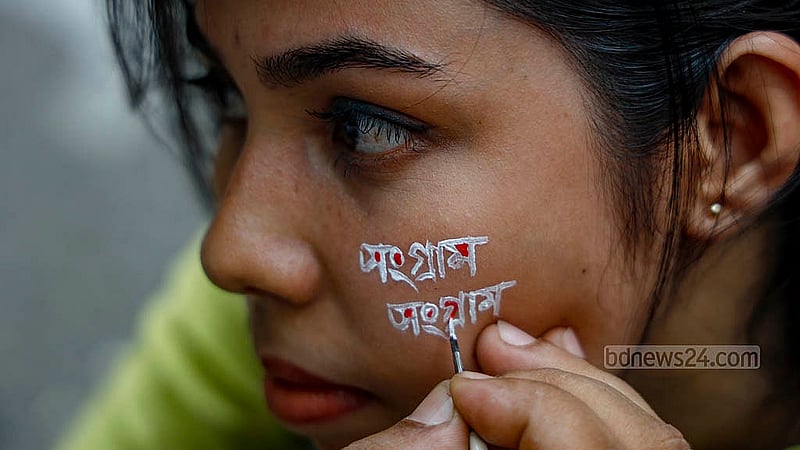 মুখে দাবিদাওয়া এঁকে শুক্রবার কাকরাইল মোড়ে আন্দোলনে যোগ দেন জগন্নাথ বিশ্ববিদ্যালয়ের এক শিক্ষার্থী। ছবি: মাহমুদ জামান অভি