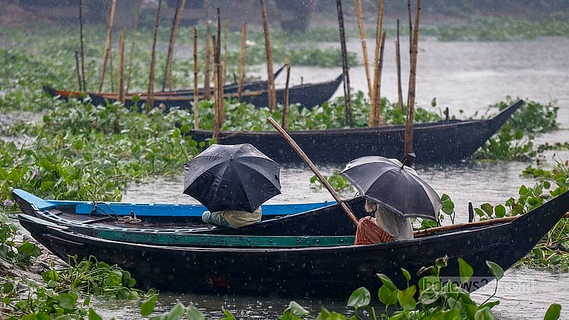 কুয়াশা আচ্ছাদিত শীতলক্ষ্যা নদীতে ডেমরা এলাকায় বুধবার দুপুরে ঝরে বৃষ্টি। তা থেকে বাঁচতে ছাতা মাথায় কয়েকজন মাঝি। ছবি: মাহমুদ জামান অভি