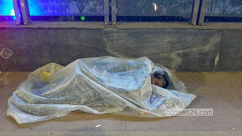 কাকরাইল এলাকায় ফুটপাতে শরীর পলিথিন মুড়ে তীব্র শীতের রাত পার করছেন ছিন্নমূল মানুষেরা।  ছবি: আব্দুল্লাহ আল মমীন