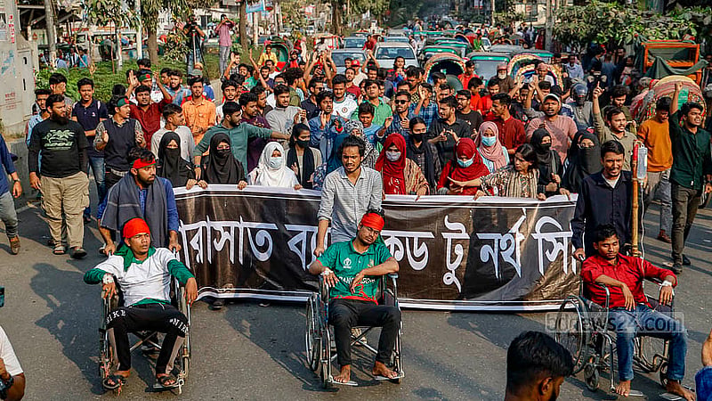 স্বতন্ত্র বিশ্ববিদ্যালয়ের দাবিতে আন্দোলনরত সরকারি তিতুমীর কলেজের শিক্ষার্থীরা সোমবার দুপুরে কলেজের সামনে থেকে মিছিল বের করেন। অনশনরত কয়েকজন শিক্ষার্থী মিছিলে অংশ নেন হুইল চেয়ারে বসে। ছবি: মাহমুদ জামান অভি