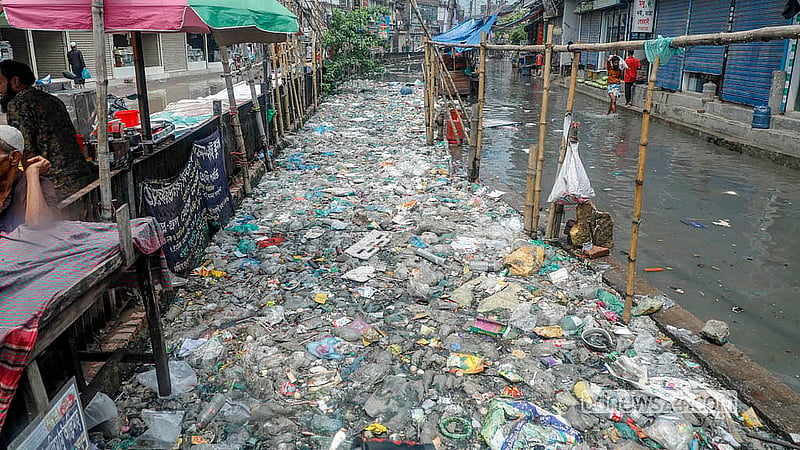 দোকানপাটের ময়লা-আবর্জনায় সারা বছর ভরে থাকে রাজধানীর যাত্রাবাড়ীর কুতুবখালী খাল; সোমবার দুপুরের বৃষ্টিতে খাল উপচে পানি উঠেছে সড়কেও