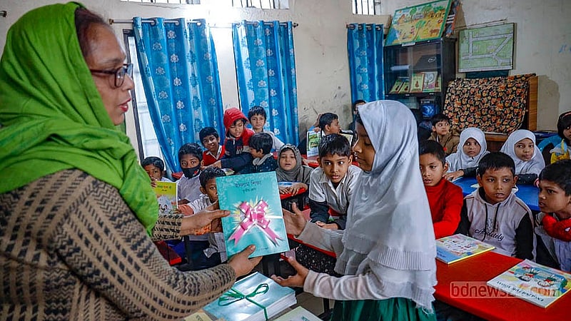 আজিমপুর আদর্শ সরকারি প্রাথমিক বিদ্যালয়ে বৃহস্পতিবার শিক্ষার্থীদের হাতে নতুন বই তুলে দিচ্ছেন এক শিক্ষক