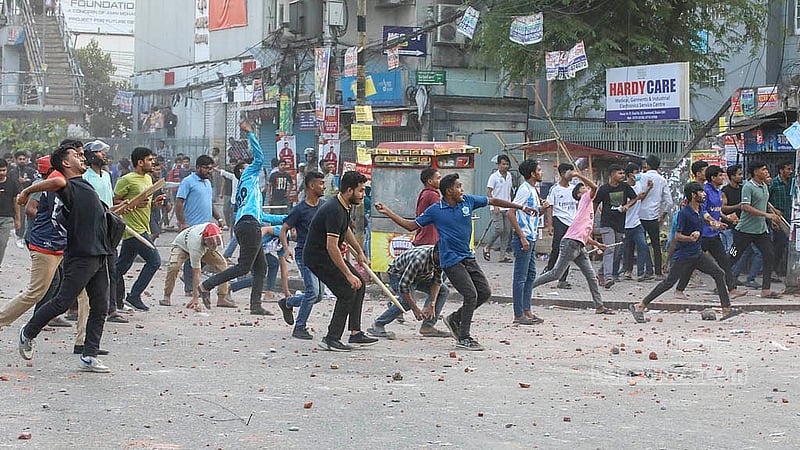 সায়েন্স ল্যাবরেটরি মোড়ে বুধবার লাঠিসোঁটা হাতে মারমুখি ঢাকা কলেজের শিক্ষার্থীরা। এসময় সিটি কলেজের শিক্ষাথীদের দিকে ঢিল ছুড়তে দেখা যায় তাদের।