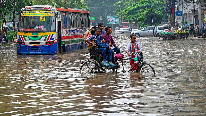 বৃষ্টিতে ঢাকার মতিঝিলের সড়কে হাঁটু সমান পানি; এর মধ্যেই চলছে যানবাহন।
