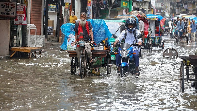 পুরান ঢাকার নাজিরাবাজার রোডে জমে থাকা পানির ওপর দিয়ে চলাচল করছে সবাই।