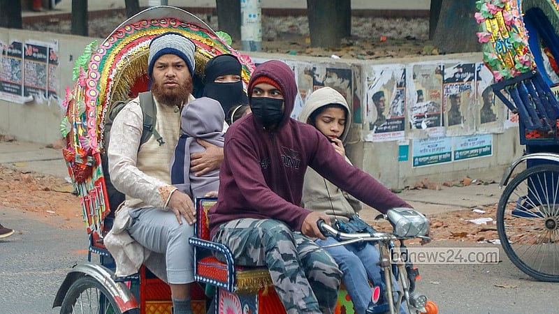 কনকনে ঠান্ডা থেকে রক্ষায় সন্তানকে গরম কাপড়ে মুড়িয়ে রিকশায় করে গন্ত্যেবের পথে এক পরিবার। ঢাকা বিশ্ববিদ্যালয় এলাকা থেকে তোলা। ছবি: আব্দুল্লাহ আল মমীন