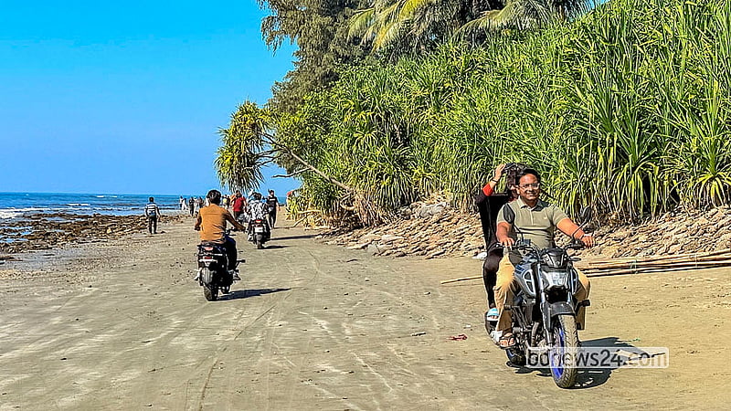 পর্যটকদের চলাচলের মধ্যে সেন্টমার্টিন দ্বীপের সৈকতে দ্রুত গতিতে মোটরসাইকেল চালাচ্ছেন কয়েকজন
