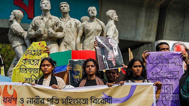 ধর্ষণ ও নারীর প্রতি সহিংসতার প্রতিবাদে রাজু ভাস্কর্যের সামনে বুধবার দুপুরে ব্যানার ও প্ল্যাকার্ড হাতে ঢাকা বিশ্ববিদ্যালয়ের থিয়েটার অ্যান্ড পারফরম্যান্স স্টাডিজ বিভাগের শিক্ষার্থীরা। ছবি: মাহমুদ জামান অভি