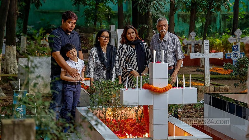 ‘অল সোলস ডেতে’ মৃতদের আত্মার শান্তি কামনায় ঢাকার ওয়ারীতে খ্রিষ্টান সমাধি ক্ষেত্রে প্রার্থনায় একটি পরিবার। ছবি: মাহমুদ জামান অভি