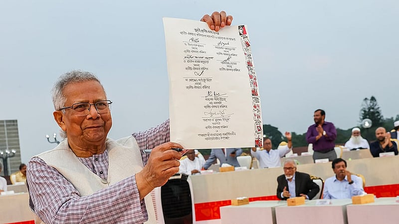 জুলাই সনদে সই করার পর তা দেখাচ্ছেন মুহাম্মদ ইউনূস। 
