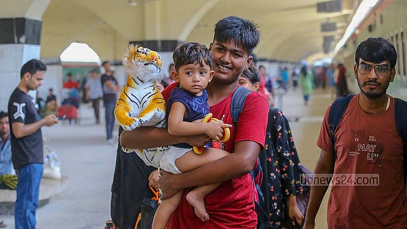 ঈদের ছুটি কাটাতে গরম উপেক্ষা করে বুধবার কমলাপুর রেল স্টেশনে বড়দের সঙ্গে বাড়ির পথে শিশুটি।