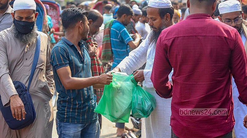 ঢাকার গুলিস্তানে ফুটপাতের দোকানিরা বিভিন্ন পণ্য ক্রেতার হাতে তুলে দেন নিষিদ্ধ পলিথিনে ভরে। ছবি: আব্দুল্লাহ আল মমীন