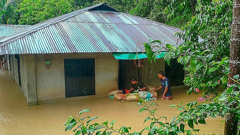 রাঙামাটিতে টানা বৃষ্টিতে নিম্নাঞ্চল প্লাবিত হয়েছে। একটি ঘরে পানি আটকানোর চেষ্টা করছেন সেখানকার বাসিন্দারা।