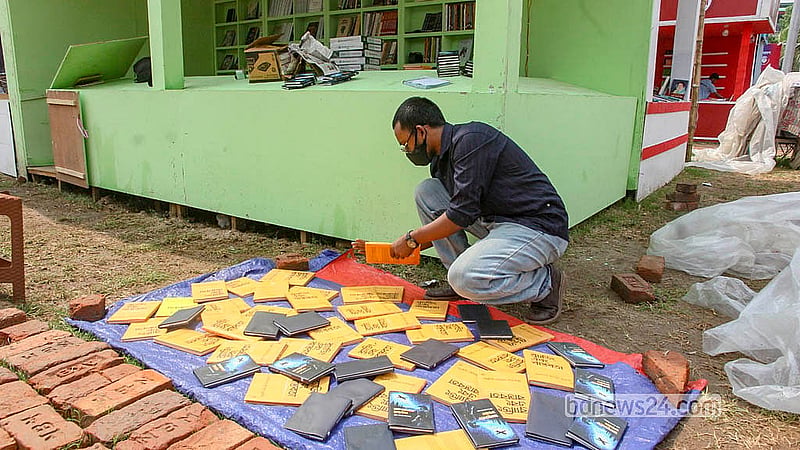 অমর একুশে বইমেলায় শুক্রবার রাতের বৃষ্টিতে ভিজে যাওয়া বই শনিবার রোদে শুকাতে দেখা যায়।