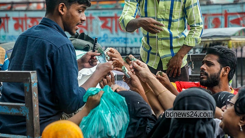 ঢাকার যাত্রাবাড়ী এলাকায় সোমবার টিসিবির ট্রাক থেকে পণ্য কিনতে টাকা হাতে মানুষের অপেক্ষা