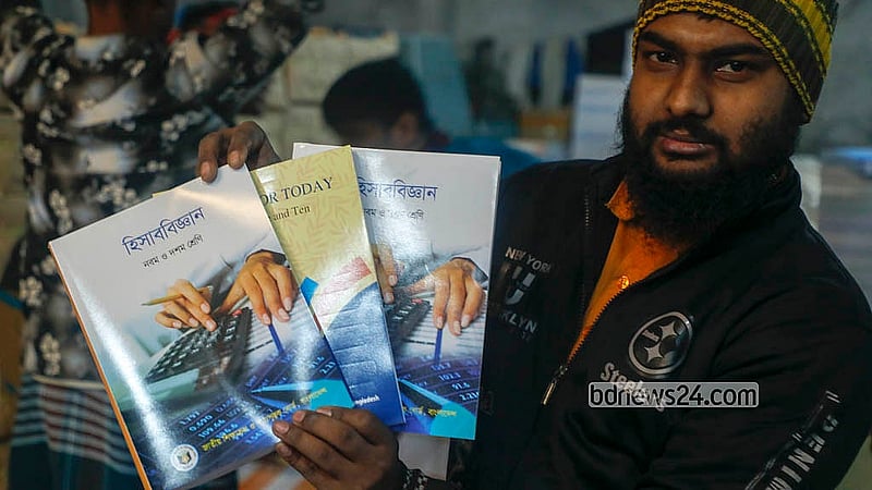 ঢাকার মাতুয়াইলের একটি ছাপাখানায় মাধ্যমিকের নতুন পাঠ্যবই হাতে এক কর্মী