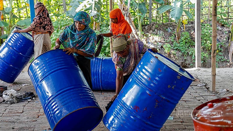 নারায়ণগঞ্জের রূপগঞ্জের তারাবো এলাকায় ‘বাগদাদ ড্রাম গুদাম’ কারখানায় রাসায়নিকের প্লাস্টিক ড্রাম পরিষ্কার করছেন নারীরা। ‘ওভার টাইম’ মিলিয়ে প্রতিদিন সকাল ৮টা থেকে রাত ১০টা পর্যন্ত তারা কাজ করেন। ছবি: মাহমুদ জামান অভি