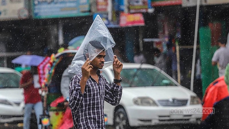 বৃষ্টির মধ্যে মাথা পলিথিনে ঢেকে চলতে দেখা যায় একজনকে। বৃহস্পতিবার রাজধানীর জুরাইন এলাকা থেকে তোলা। ছবি: আব্দুল্লাহ আল মমীন