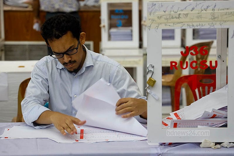 রাবির কাজী নজরুল ইসলাম মিলনায়তনে বৃহস্পতিবার রাতে ‘৩৬ জুলাই’ হলের ব্যালট বাক্স খুলে ভোট গণনার কাজ করছেন শিক্ষকরা। ছবি:মাহমুদ জামান অভি