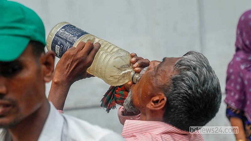 গরমের মধ্যে পথচারীরা তৃষ্ণা মেটাতে ইত্তেফাক মোড়ে বঙ্গভবন কলোনি এলাকায় ফুটপাতে থাকা কল থেকে পানি খেয়ে থাকেন