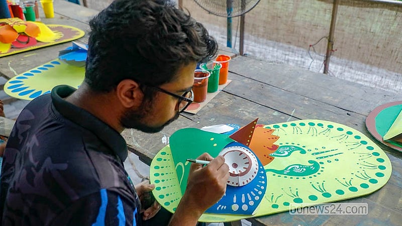 ঢাকা বিশ্ববিদ্যালয়ের চারুকলা অনুষদে বুধবার কাগজের তৈরি মুখোশে রঙ করেন এক শিক্ষার্থী