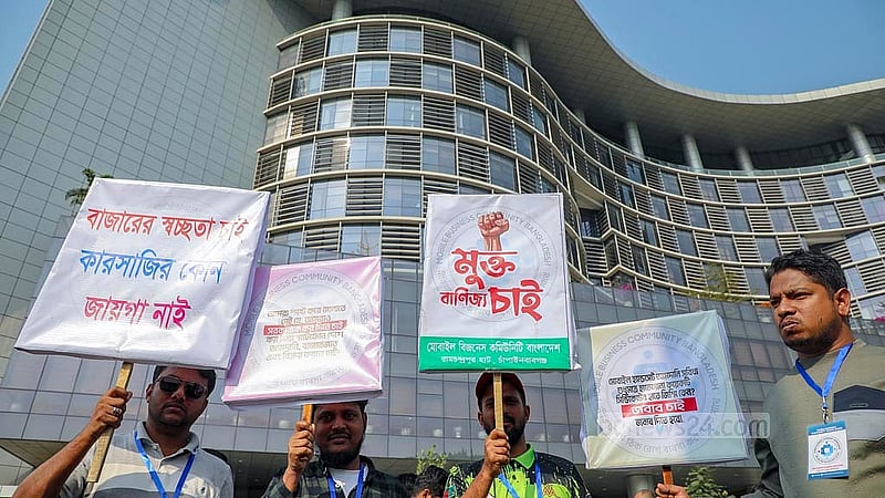অননুমোদিত মোবাইল ফোন বন্ধ করার সরকারি সিদ্ধান্তের প্রতিবাদে রোববার ঢাকার আগারগাঁও বিটিআরসি ভবনের সামনে দাবি সংবলিত প্লেকার্ড হাতে বসায়ীরা।