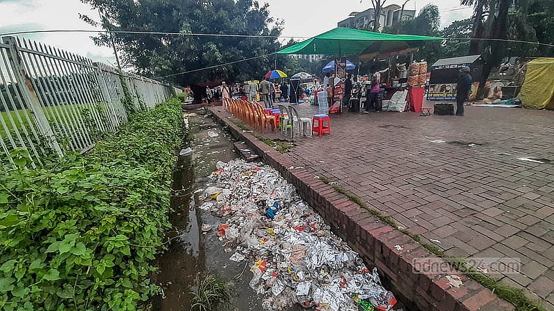 সংসদ ভবনের সীমানা ঘেঁষা মানিক মিয়া অ্যাভিনিউয়ের ফুটপাতে আবর্জনা ফেলছে শতাধিক ভ্রাম্যমাণ দোকান। বৃষ্টির কারণে আবর্জনা পচে দুর্গন্ধ ছড়ানোর পাশাপাশি জন্মাচ্ছে মশা। ছবি: আব্দুল্লাহ আল মমীন
