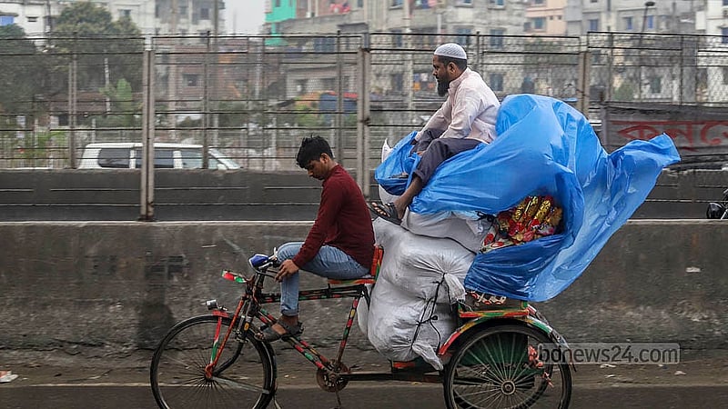 বৃষ্টির মধ্যে রিকশায় মালামাল সুরক্ষায় পলিথিনে ঢেকে গন্তব্যে ছুটছেন এক ব্যক্তি। ছবি: আব্দুল্লাহ আল মমীন