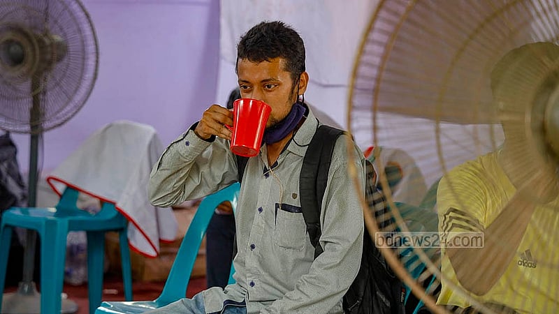 ঢাকার ফার্মগেইট মোড়ে বাংলাদেশ রেড ক্রিসেন্ট সোসাইটির বানানো বিশ্রামাগারে মঙ্গলবার দুপুরে পানি পান করছেন ঘর্মাক্ত একজন। ছবি: মাহমুদ জামান অভি