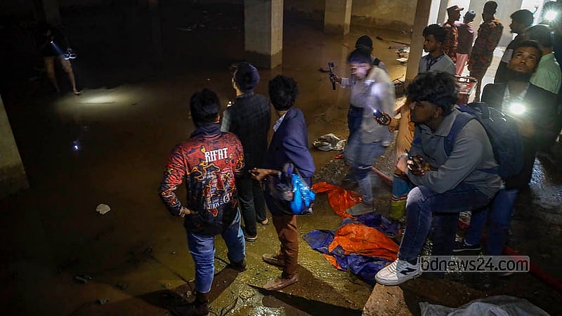 ধানমন্ডির ৩২ নম্বরে বঙ্গবন্ধুর বাড়ি লাগোয়া একটি নির্মাণাধীন ভবনের বেজমেন্ট নিয়ে আলোচনার পর রোববার সেখান থেকে পানি সরায় ফায়ার সার্ভিস। সেই কর্মযজ্ঞ দেখতে ভিড় করেন উৎসুক লোকজন। ছবি: মাহমুদ জামান অভি