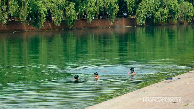 বৈশাখের তপ্ত দুপুরে জাতীয় সংসদ ভবন এলাকার ক্রিসেন্ট লেকে গোসল করছেন কয়েক কিশোর