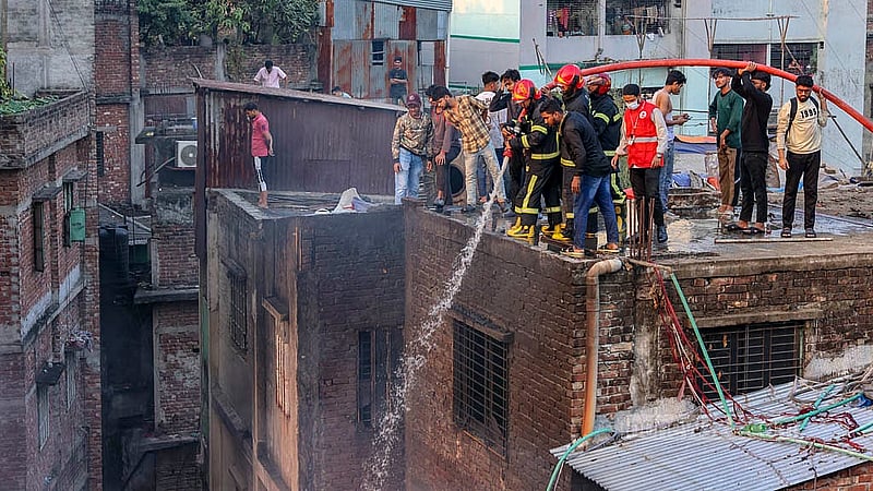 ইসলামবাগের চেয়ারম্যানঘাট এলাকায় আগুন লাগা প্লাস্টিকের গুদামের আশপাশে উঁচু ভবন রয়েছে। সেখানে এক ভবন থেকে অন্য ভবনে পানি ছেটান ফায়ার সার্ভিসের কর্মীরা।
