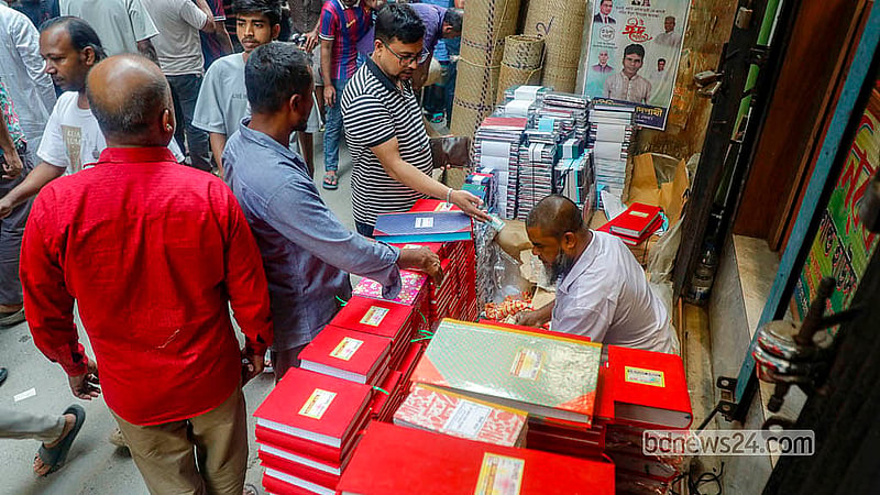 পুরান ঢাকার তাঁতীবাজার সড়কে বিভিন্ন আকারের হালখাতার নিয়ে বসেছেন অস্থায়ী দোকানিরা। নববর্ষ ঘিরে বেচাকেনা চলছে বেশ।  ছবি: আব্দুল্লাহ আল মমীন